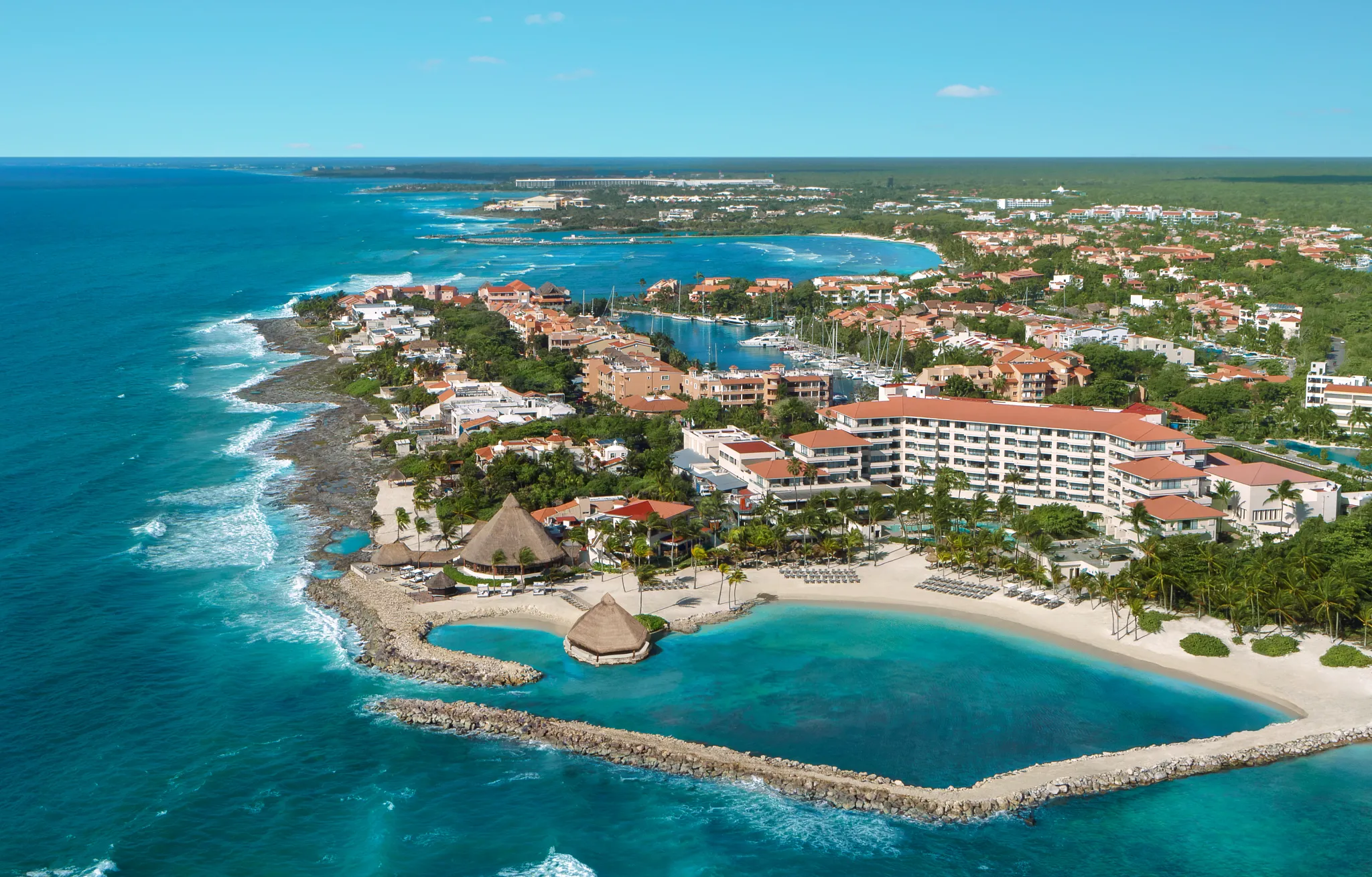 Aerial view of Dreams Aventuras Riviera Maya resort with marina, beach, and turquoise Caribbean waters.
