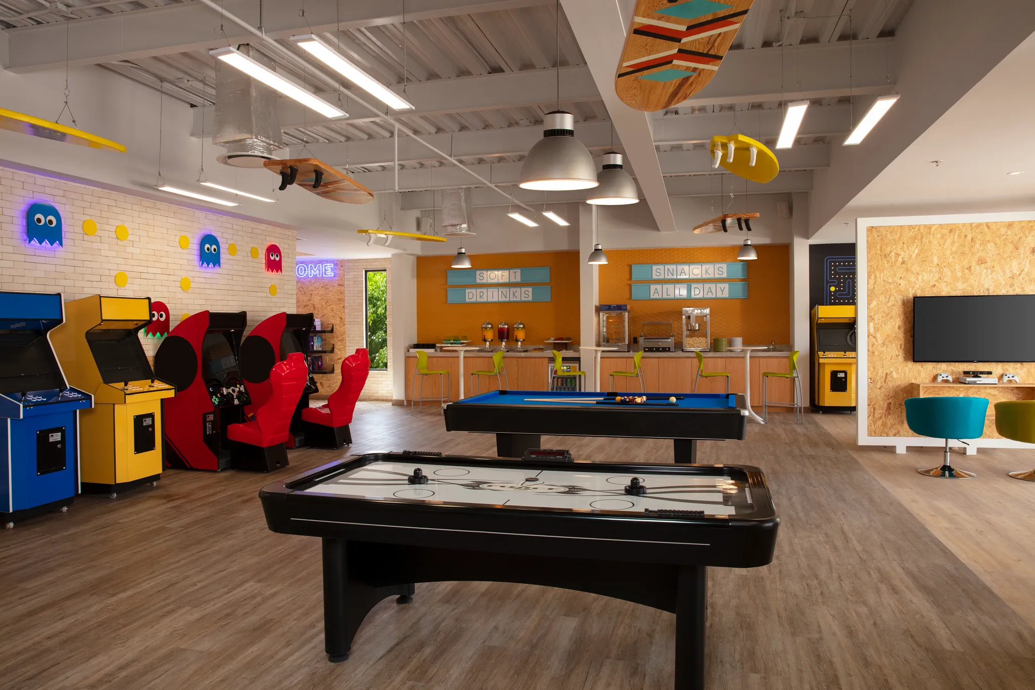 Bright teen game room with arcade machines, pool table, and snack bar at Dreams Aventuras Riviera Maya.