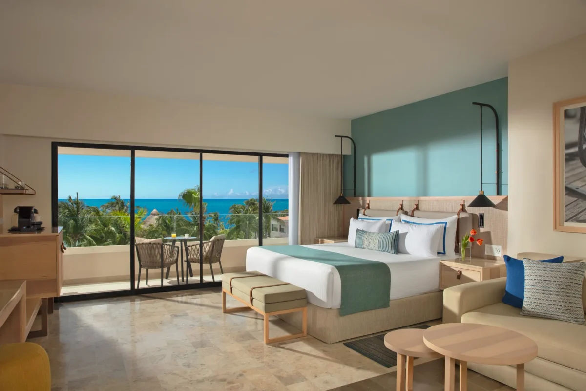 Deluxe Ocean View room with king bed and private balcony overlooking the Caribbean Sea at Dreams Aventuras Riviera Maya.