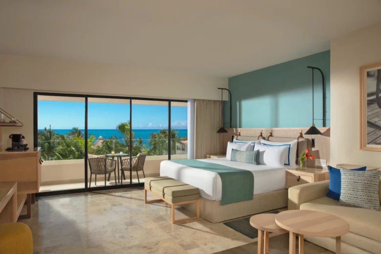Deluxe Ocean View room with king bed and private balcony overlooking the Caribbean Sea at Dreams Aventuras Riviera Maya.