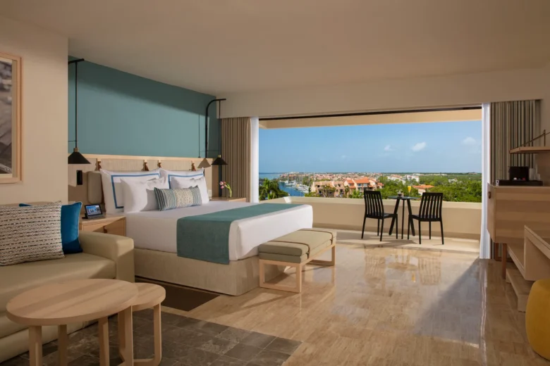 Deluxe room with king bed and private balcony overlooking marina view at Dreams Aventuras Riviera Maya.