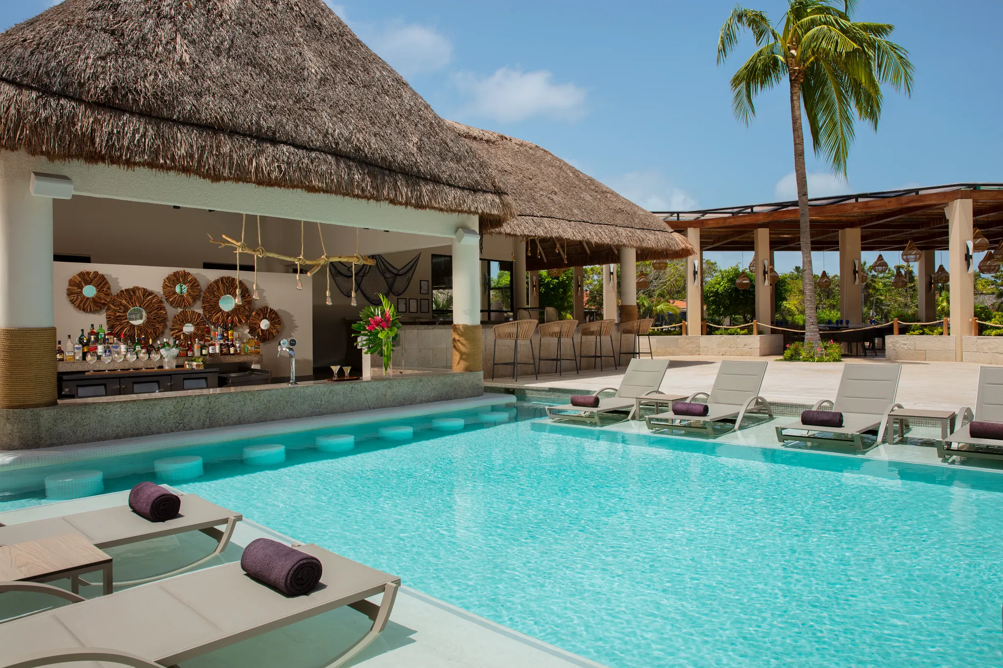 Manatees swim-up bar at Dreams Aventuras Riviera Maya featuring a lively poolside setting, in-water seating, and tropical cocktails.