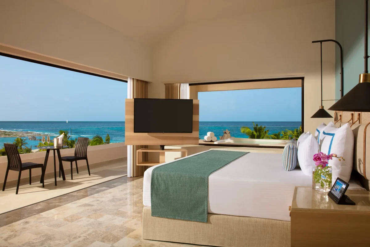 Preferred Club Honeymoon Ocean View suite with king bed and balcony at Dreams Aventuras Riviera Maya.
