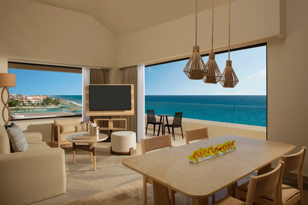 Preferred Club Master Suite Ocean Front with living area, dining space, and balcony overlooking the Caribbean Sea at Dreams Aventuras Riviera Maya.