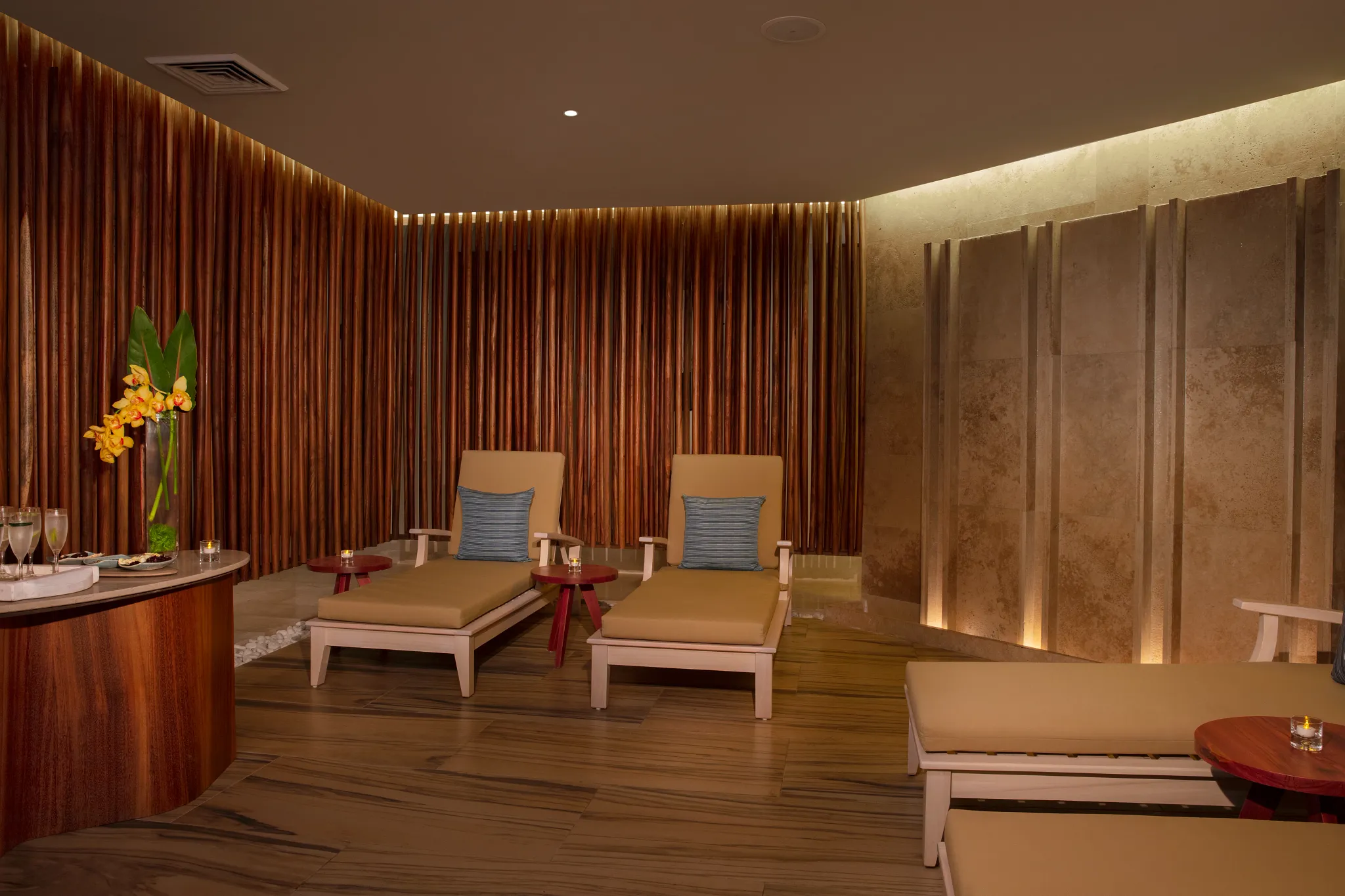 Indoor spa relaxation lounge with cushioned chairs and warm wood accents at Dreams Aventuras Riviera Maya.