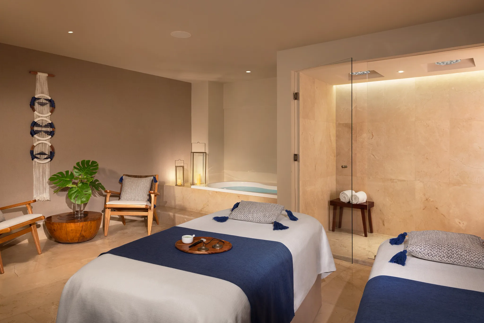 Spa treatment room with massage beds, soaking tub, and soft lighting at Dreams Aventuras Riviera Maya.